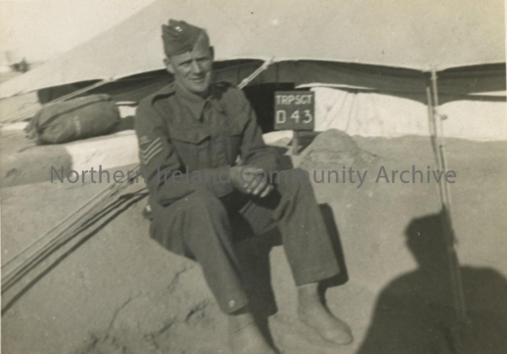 Soldier sitting beside a tent.