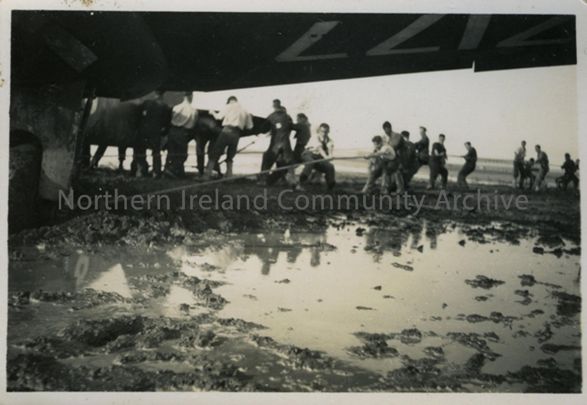 Soldiers pulling aircraft out of mud