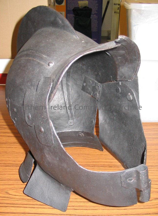 helmet. date unknown; has a hinged face guard, opening as two halves across face; a large fin extends from headpiece; restored by Ulster Museum 1992. – 1998.38 (1)