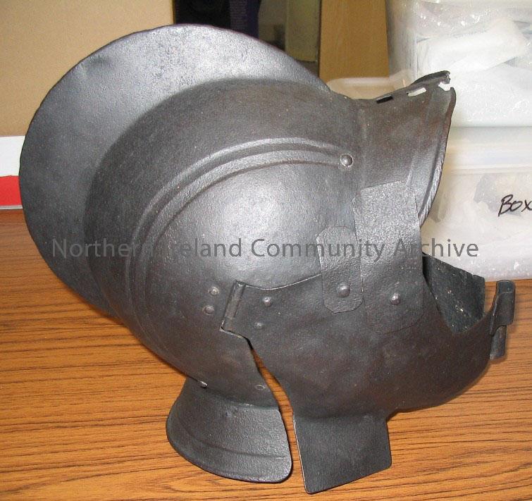 helmet. date unknown; has a hinged face guard, opening as two halves across face; a large fin extends from headpiece; restored by Ulster Museum 1992. – 1998.38 (2)