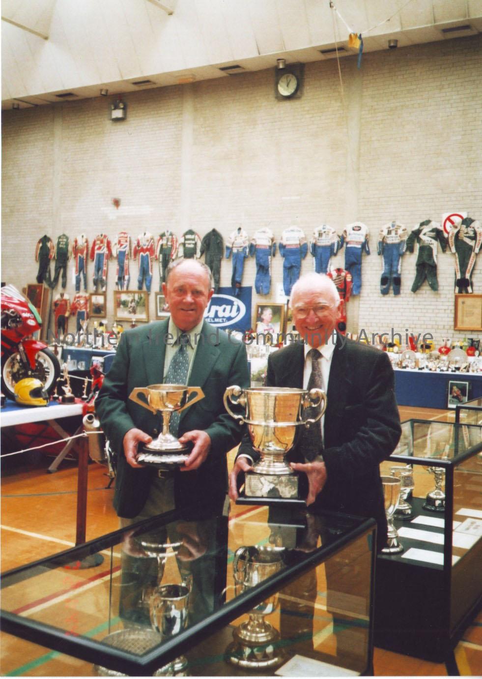 Photographs from Joey Dunlop exhibition May 2003. Photos include, Manxman Alan (W.A) Holmes (Dark Suit) with long time friend, local resident Jim McDe… – 2011.73