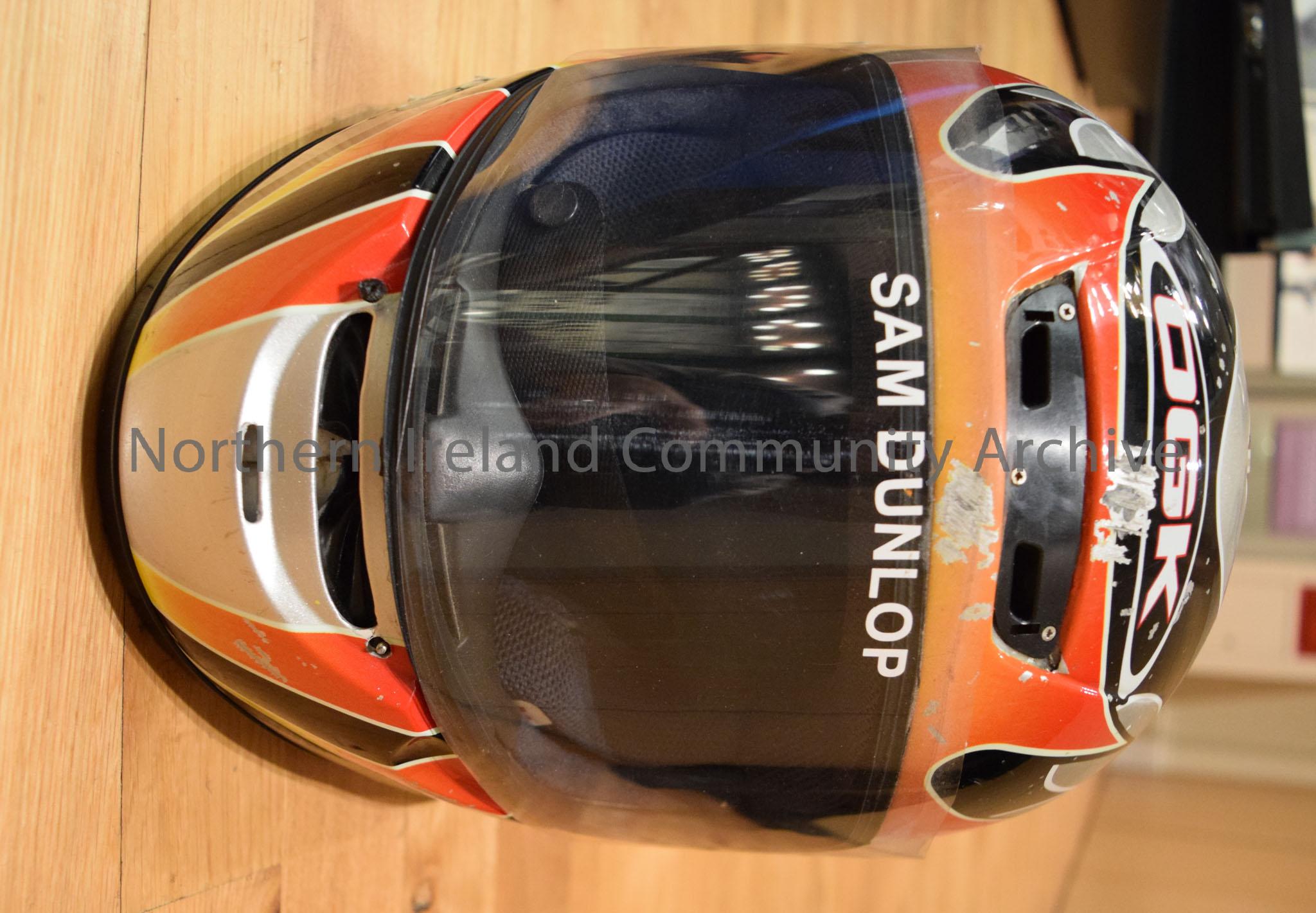 OGK motorcycle helmet belonging to Sam Dunlop. Grey helmet with black stripes and red and orange flame effects on the side and a red and orange curved… – 2016.114 (2)