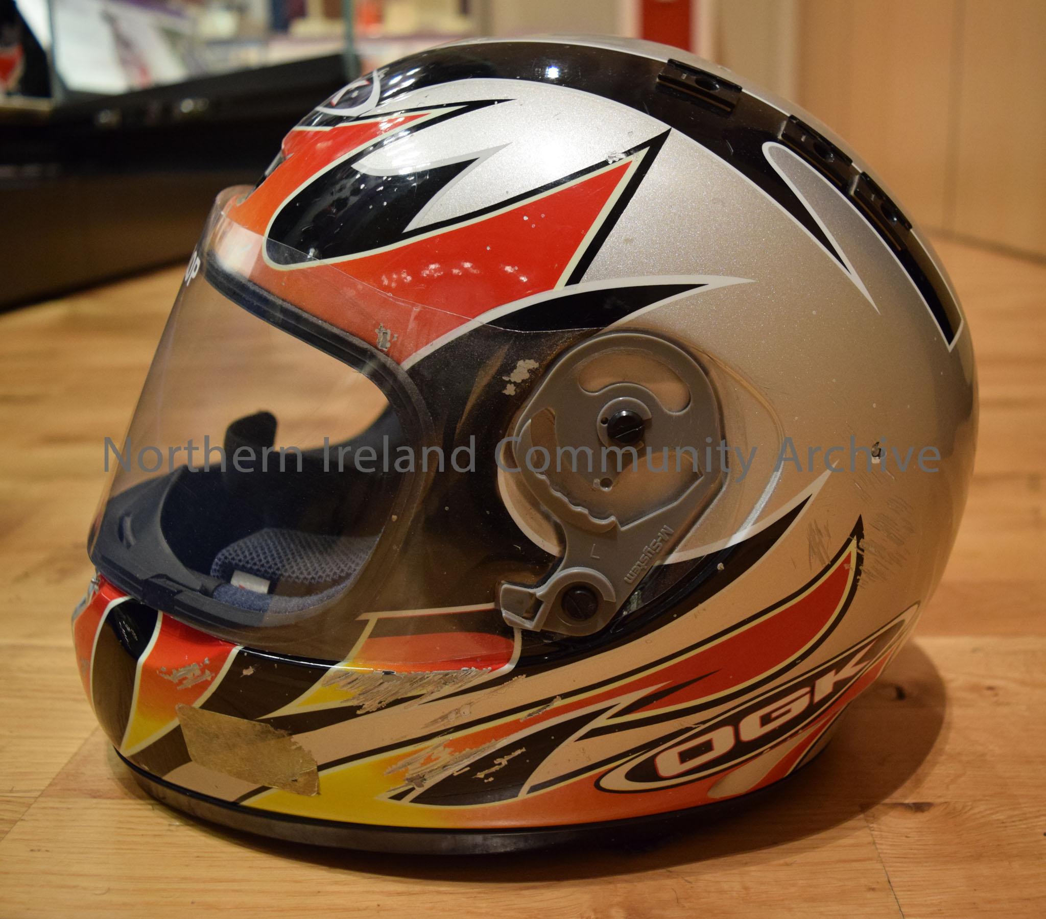 OGK motorcycle helmet belonging to Sam Dunlop. Grey helmet with black stripes and red and orange flame effects on the side and a red and orange curved… – 2016.114 (3)