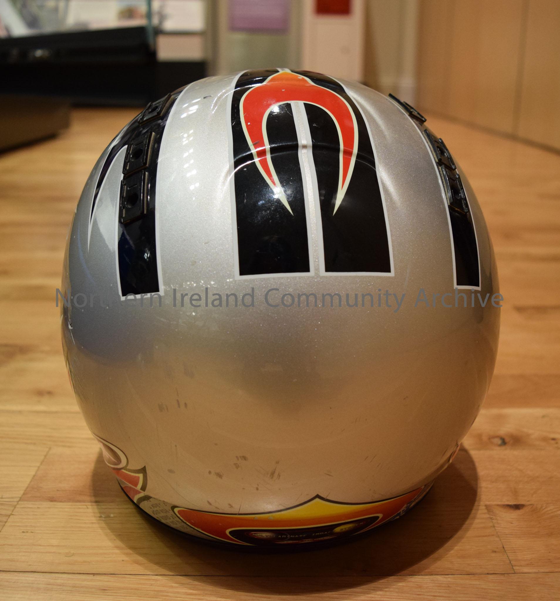 OGK motorcycle helmet belonging to Sam Dunlop. Grey helmet with black stripes and red and orange flame effects on the side and a red and orange curved… – 2016.114 (4)