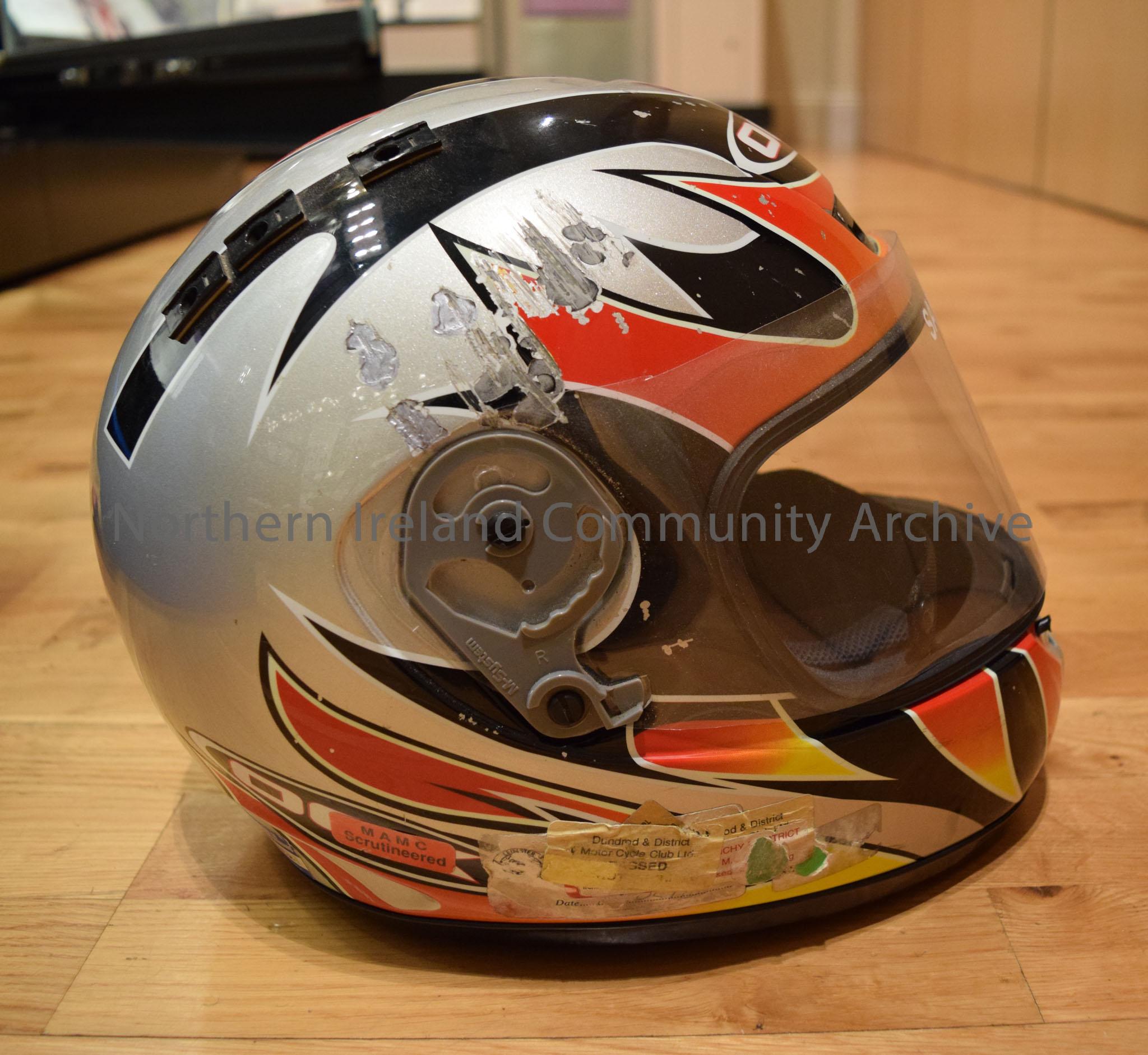 OGK motorcycle helmet belonging to Sam Dunlop. Grey helmet with black stripes and red and orange flame effects on the side and a red and orange curved… – 2016.114 (5)