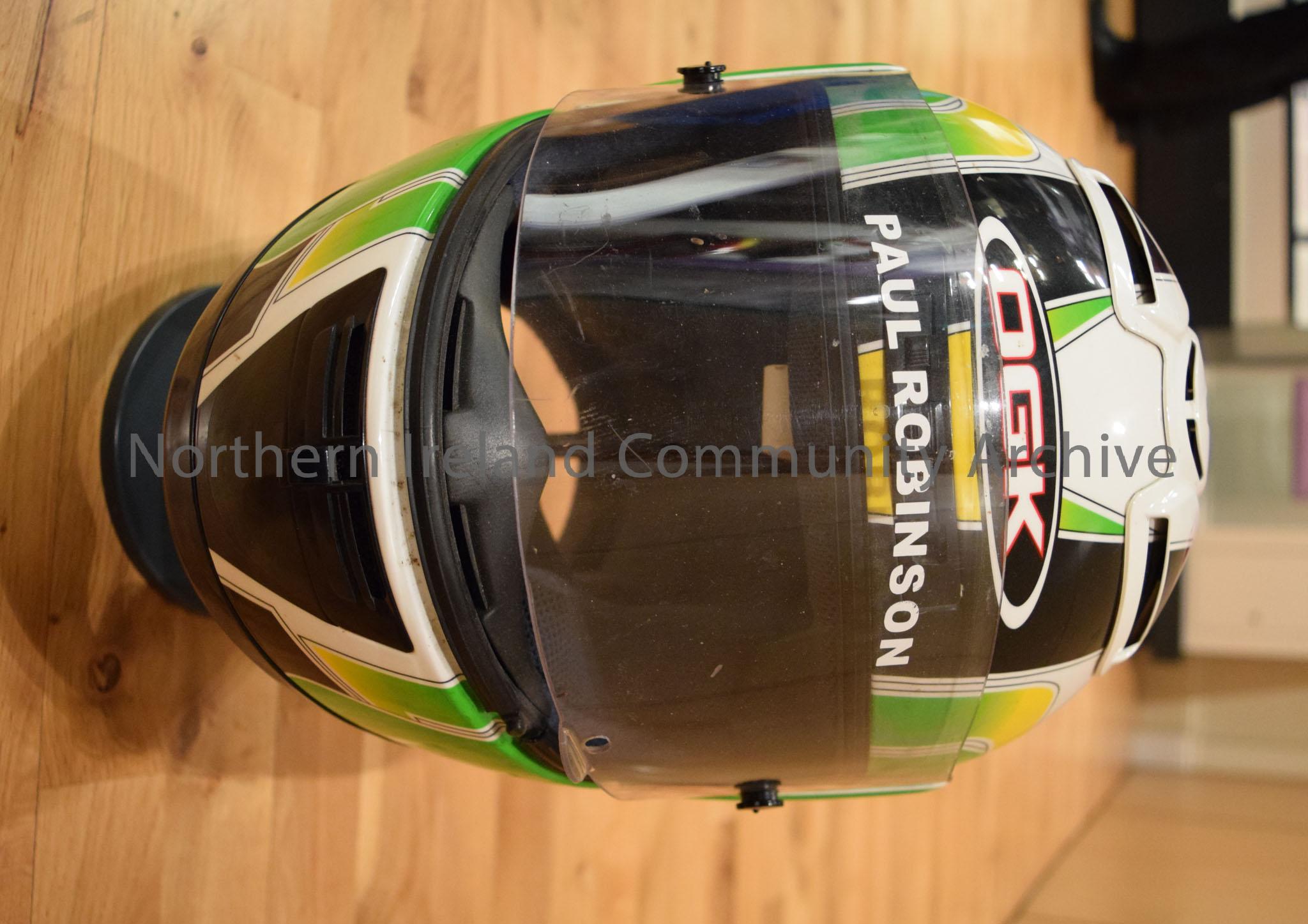 OGK motorcycle helmet belonging to Paul Robinson. White helmet with two “z” shaped black stripes and green and yellow sides. – 2016.116 (2)