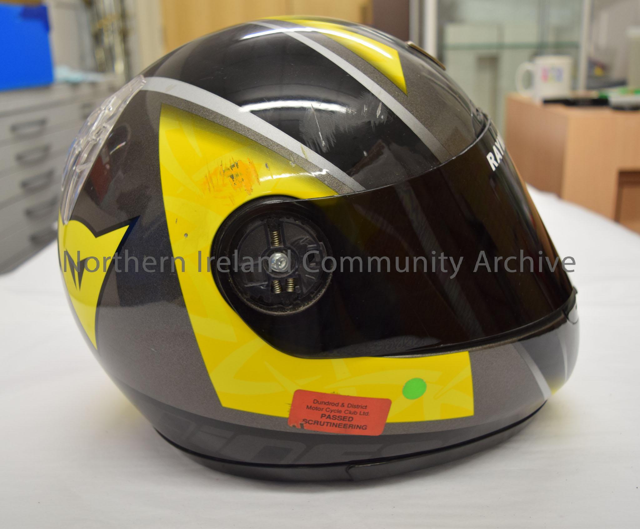 Dainese motorcycle helmet belonging to Raymond Hodge. Black, silver and yellow helmet with black visor and triangular shaped logo on the front. – 2016.12 (5)