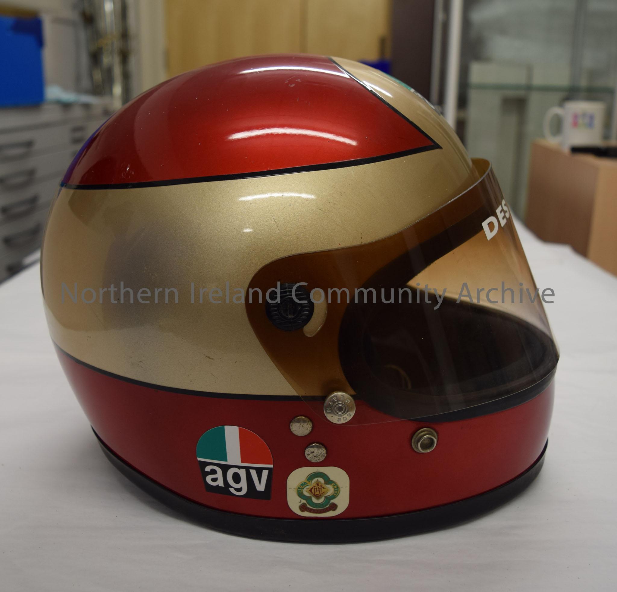 AGV motorcycle helmet belonging to Des Barry. Dark red helmet with gold band around the middle with black trim and tinted visor. – 2016.14 (5)