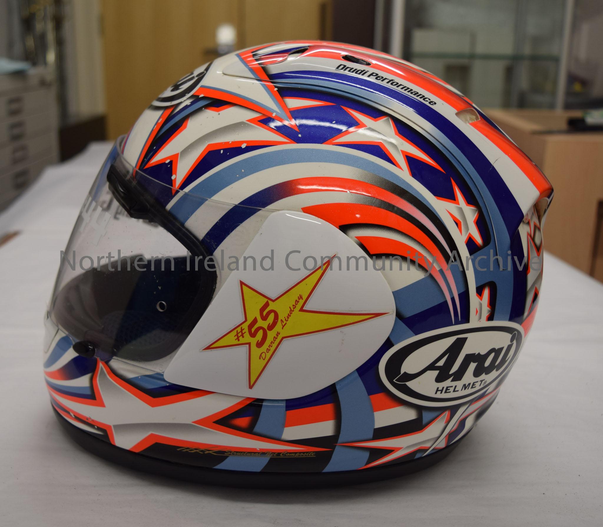 Arai Helmet belonging to Craig Gibson #44. White with blue stripes and silver stars with orange trim – 2016.30 (3)