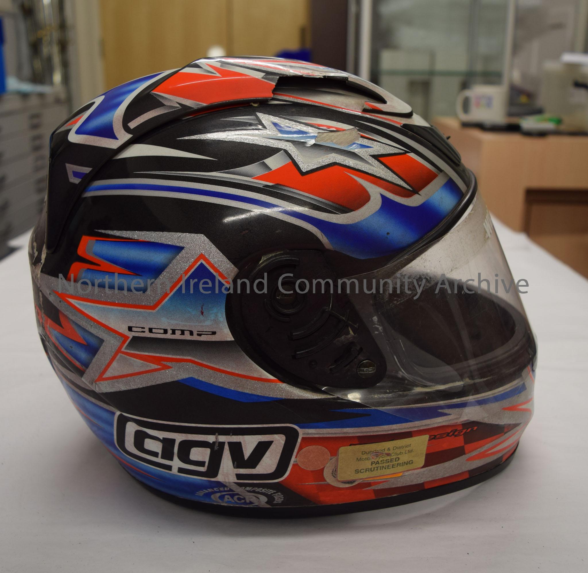AGV helmet belonging to Willie Gibson. Black with white orange and blue pattern with black and orange check running down the middle – 2016.31 (5)