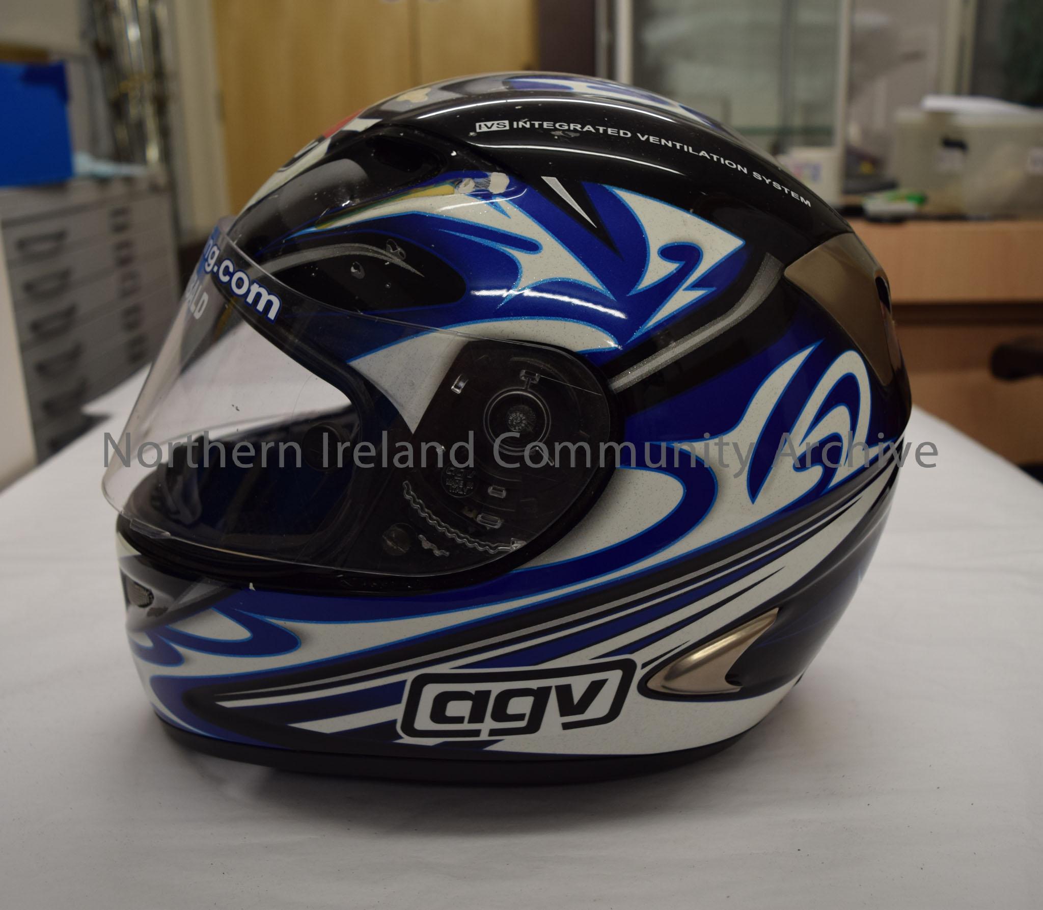 AGV motorcycle helmet belonging to Adrian Archibald. Black helmet with blue, white and silver tribal style pattern on it. Two vents on the chin strap. – 2016.39 (3)