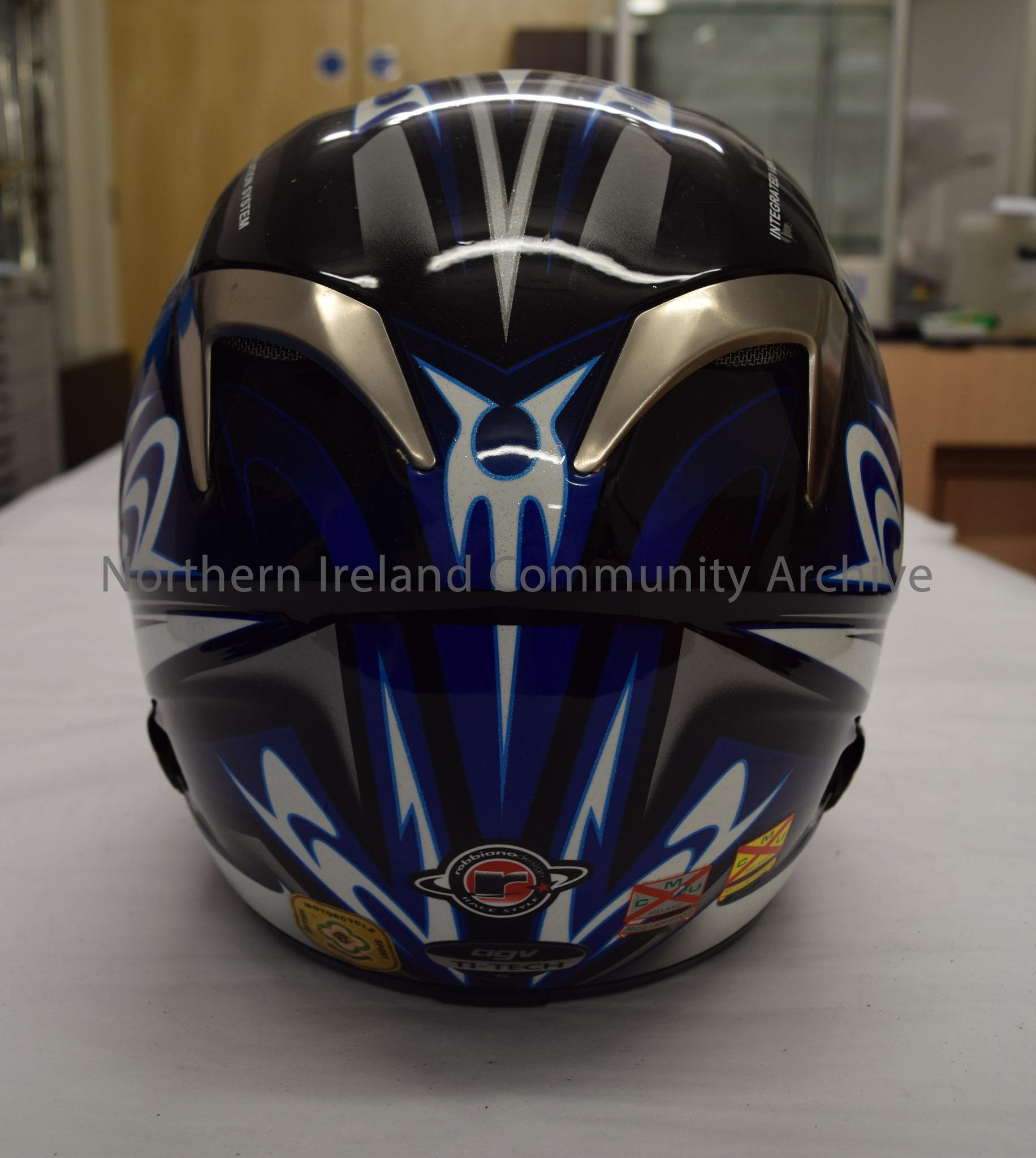 AGV motorcycle helmet belonging to Adrian Archibald. Black helmet with blue, white and silver tribal style pattern on it. Two vents on the chin strap. – 2016.39 (4)