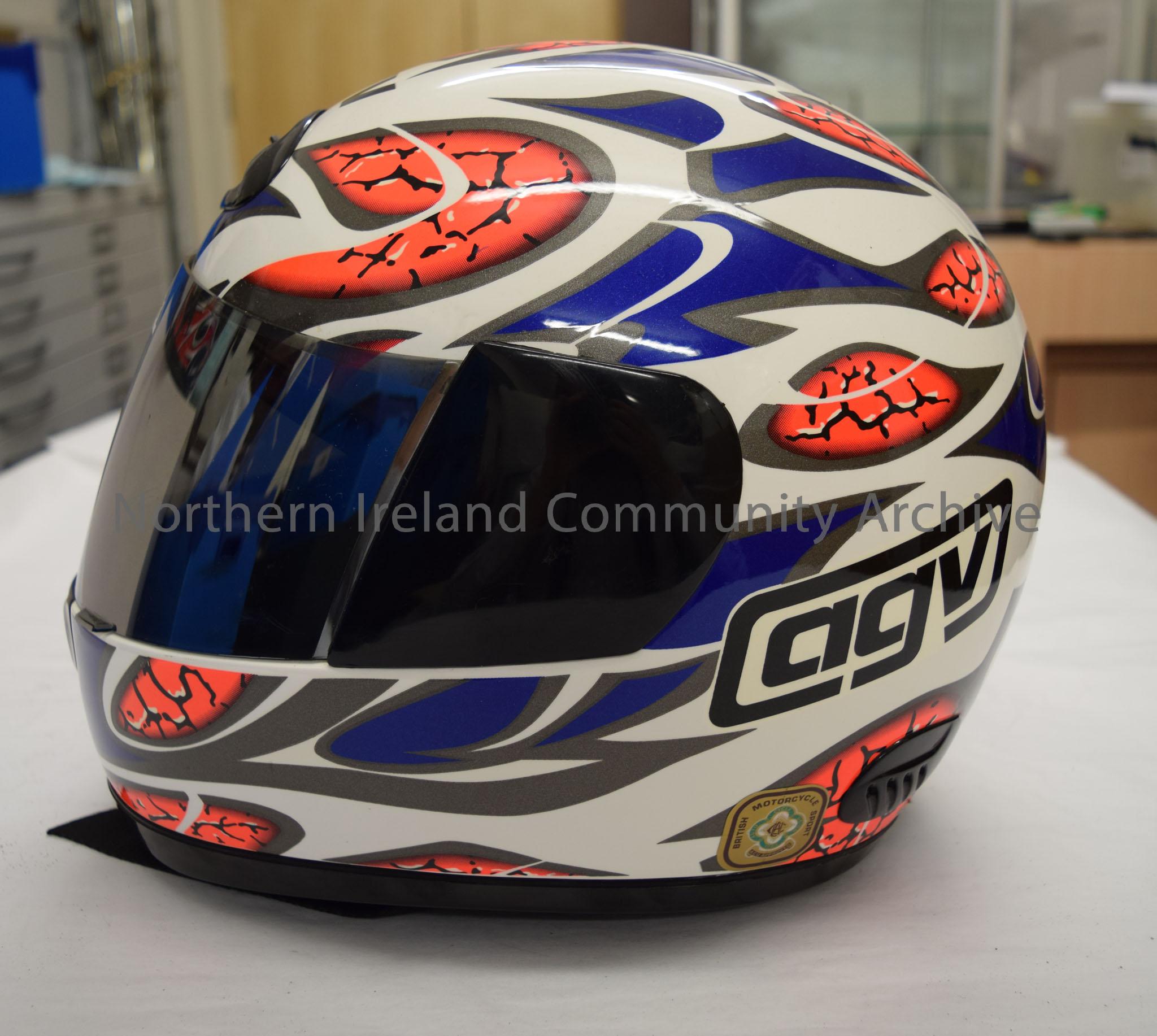 AGV motorcycle helmet belonging to Steve Ball. White helmet with blue and grey pattern and sections in bright orange designed to look a bit like a bra… – 2016.66 (3)