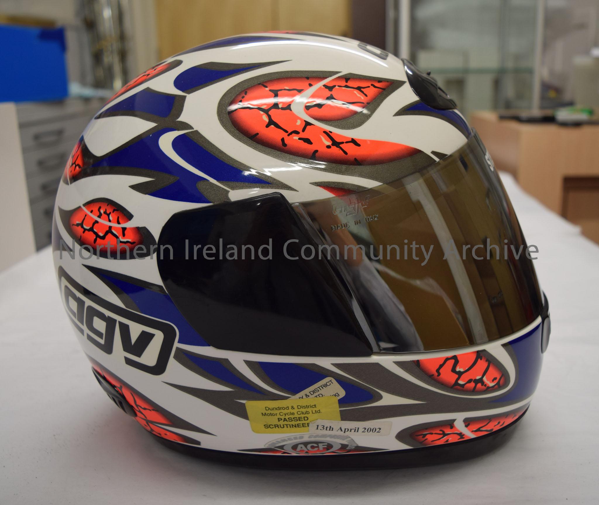 AGV motorcycle helmet belonging to Steve Ball. White helmet with blue and grey pattern and sections in bright orange designed to look a bit like a bra… – 2016.66 (5)