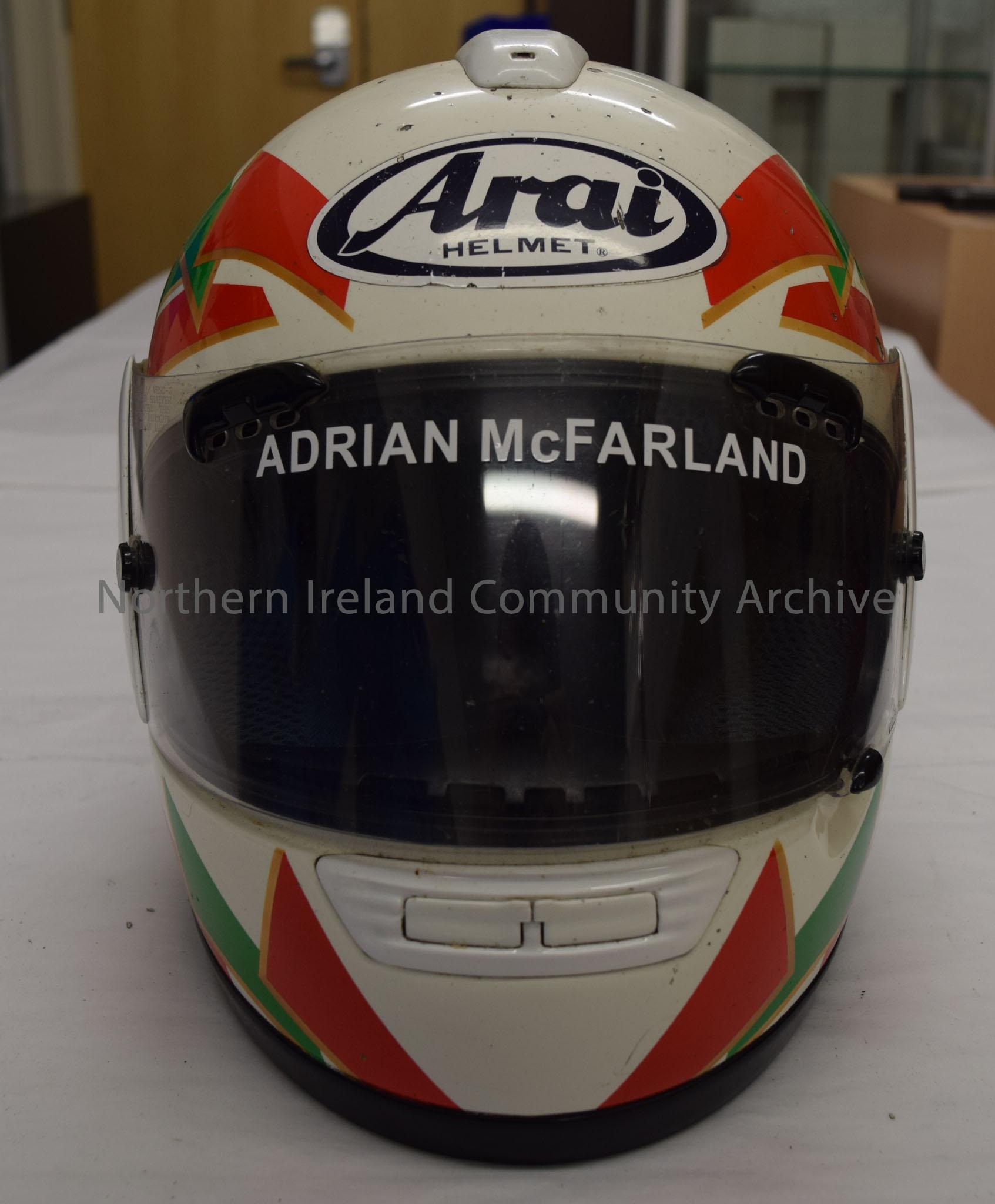Arai motorcycle helmet belonging to Adrian McFarland. White helmet with red and green trapezium shape pattern with gold borders. – 2016.67 (2)