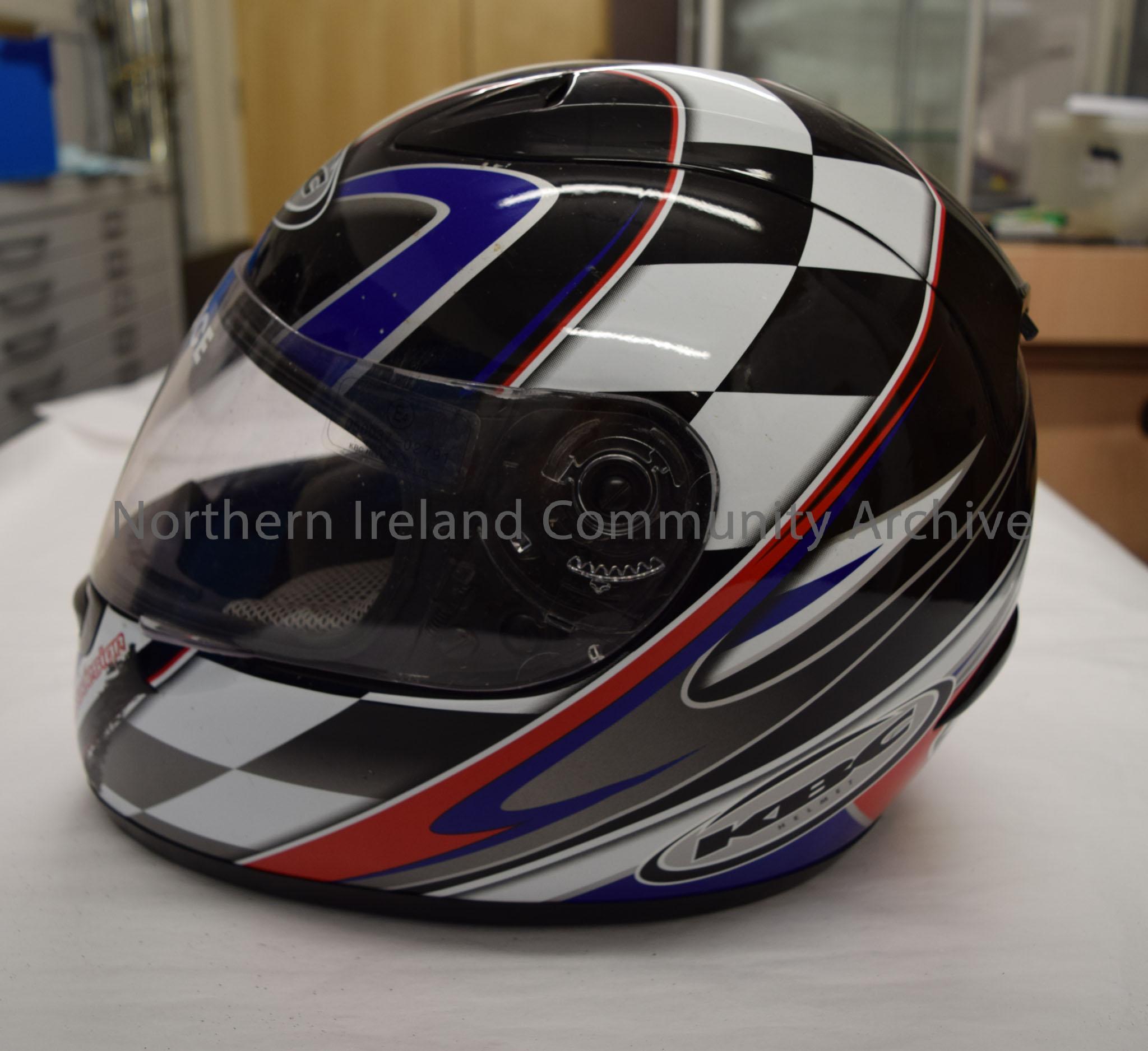 KBC motorcycle helmet belonging to Keith Bruce. Black and white chequered pattern with blue and red stripes. – 2016.75 (3)