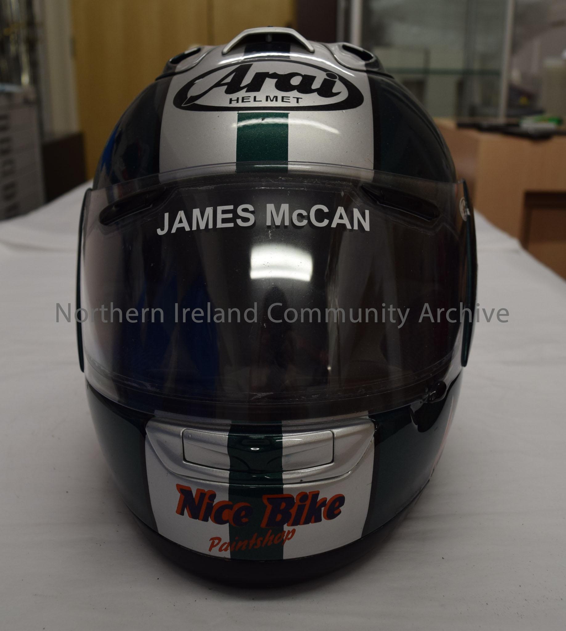 Arai motorcycle helmet belonging to James McCann. Dark green with silver stripes down the middle, orange squiggle on the side and an image of the cart… – 2016.85 (2)