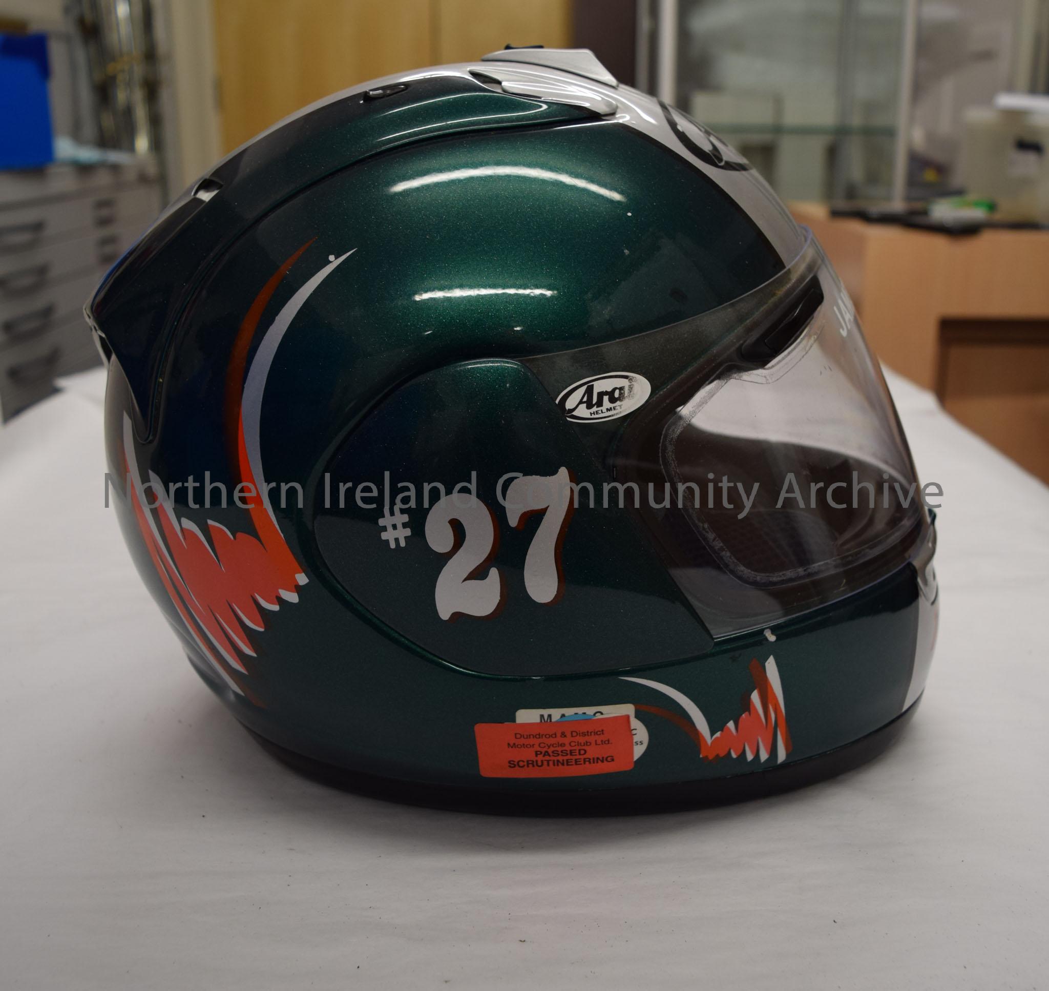 Arai motorcycle helmet belonging to James McCann. Dark green with silver stripes down the middle, orange squiggle on the side and an image of the cart… – 2016.85 (5)