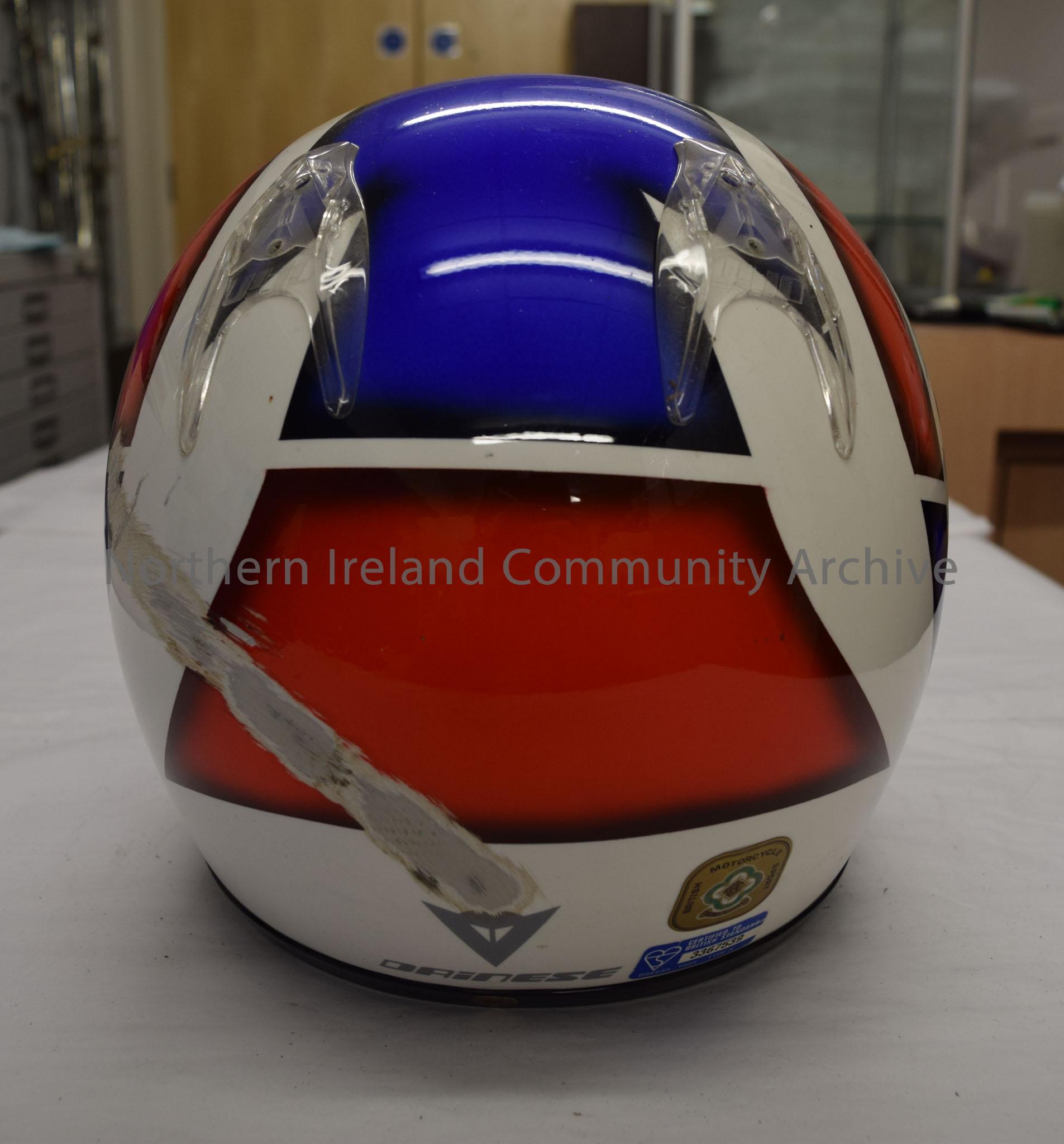 Dainese motorcycle helmet belonging to Paul Robinson. White helmet with blue stripe down the middle, blue chin bar and a red pattern on the sides. “Ma… – 2016.87 (4)