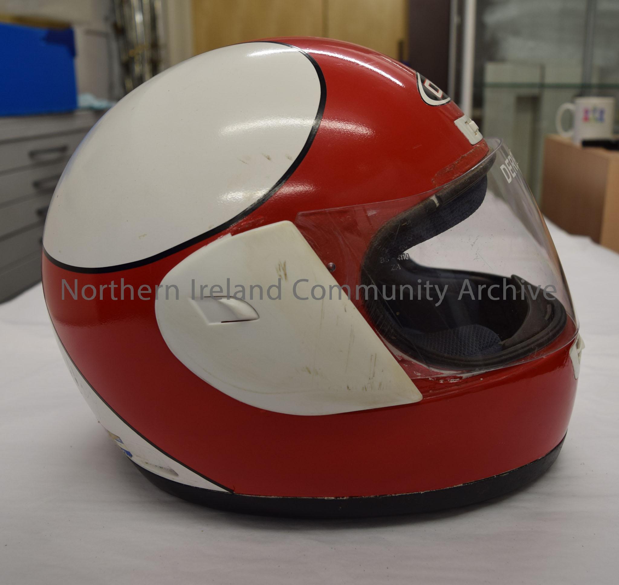 OGK motorcycle helmet belonging to Derek McCooke. Red at the front reaching back to three points on a white background pointing at a black star with r… – 2016.9 (5)