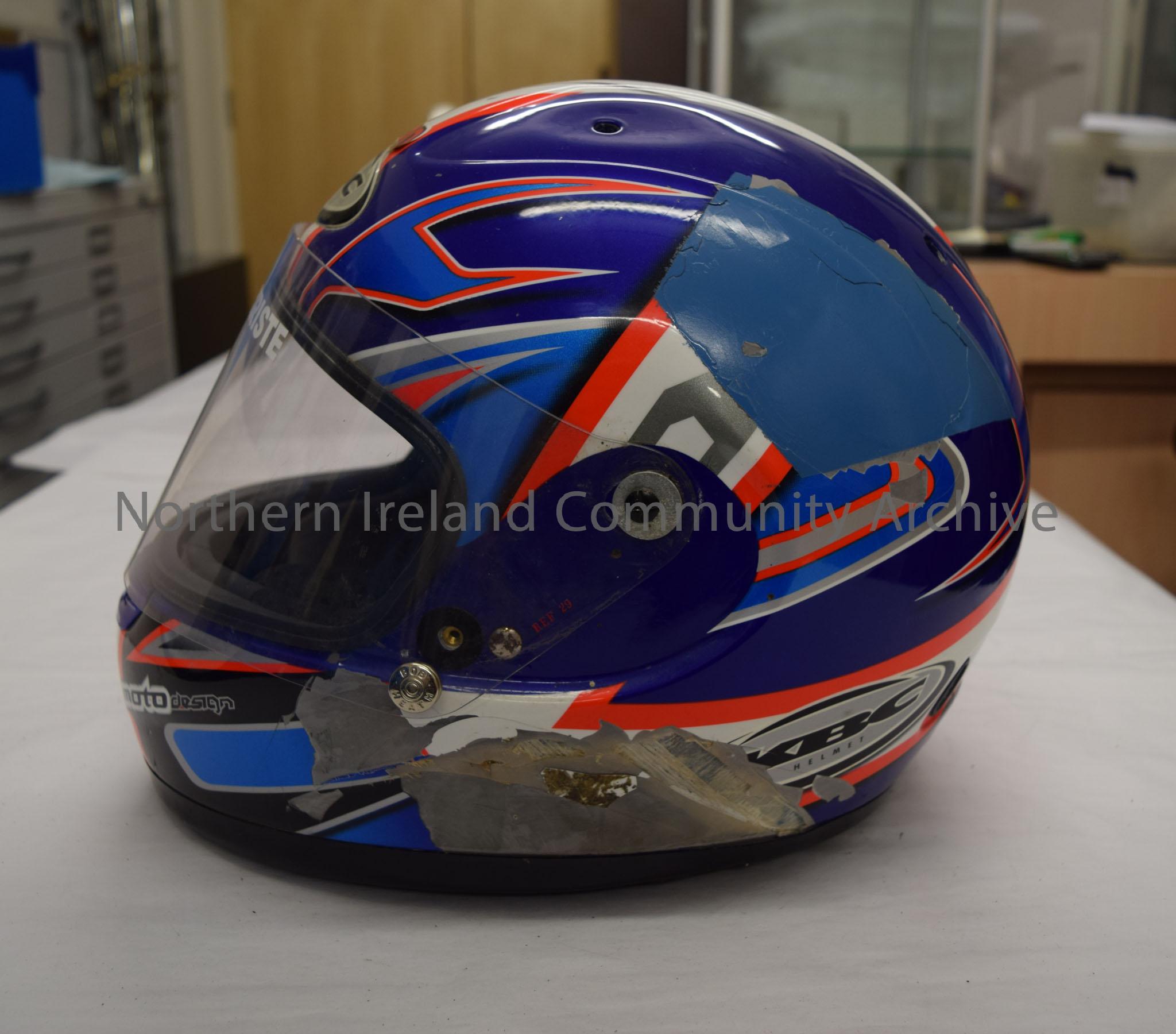 KBC motorcycle helmet belonging to James Christie. Dark blue helmet with white stripe down the middle and a blue, bright orange, white and silver patt… – 2016.92 (3)