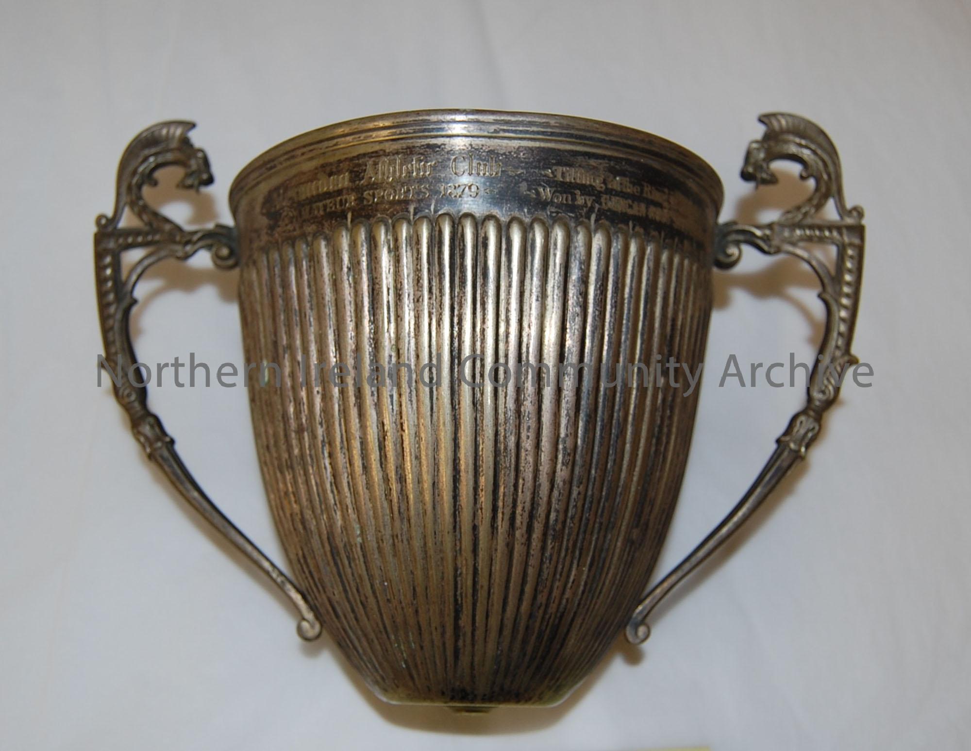 Silver coloured cup with two handles and the base missing.