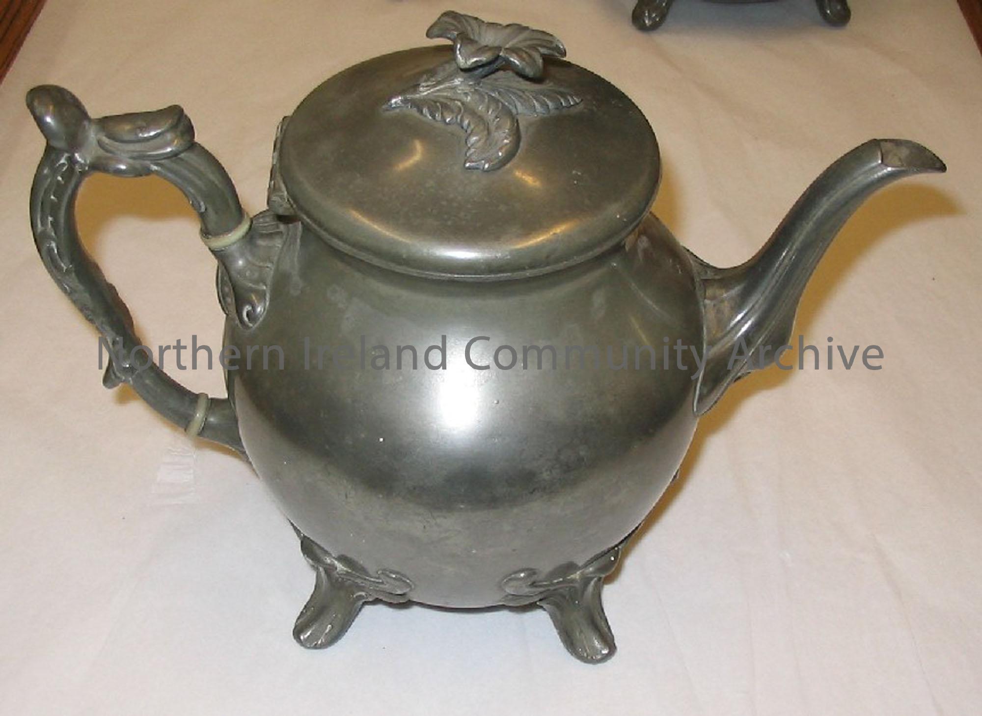 Pear shaped pewter coloured teapot with a plain body and flat lid.