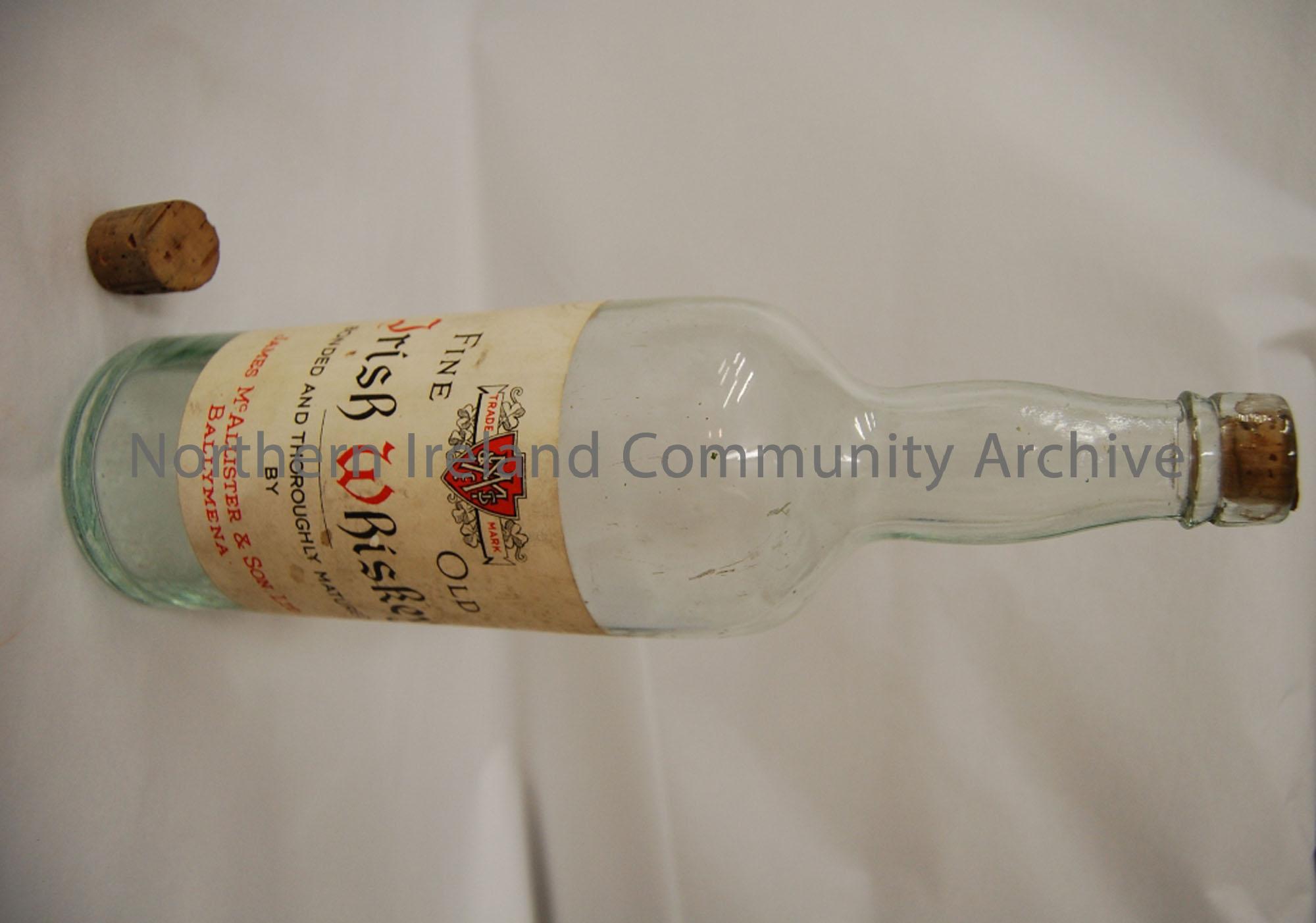 ‘Fine Old Irish Whiskey, bonded and thoroughly matured by James McAllister and Sons Ltd, Ballymena.’ Clear heavy glass with cork. Company name printed…