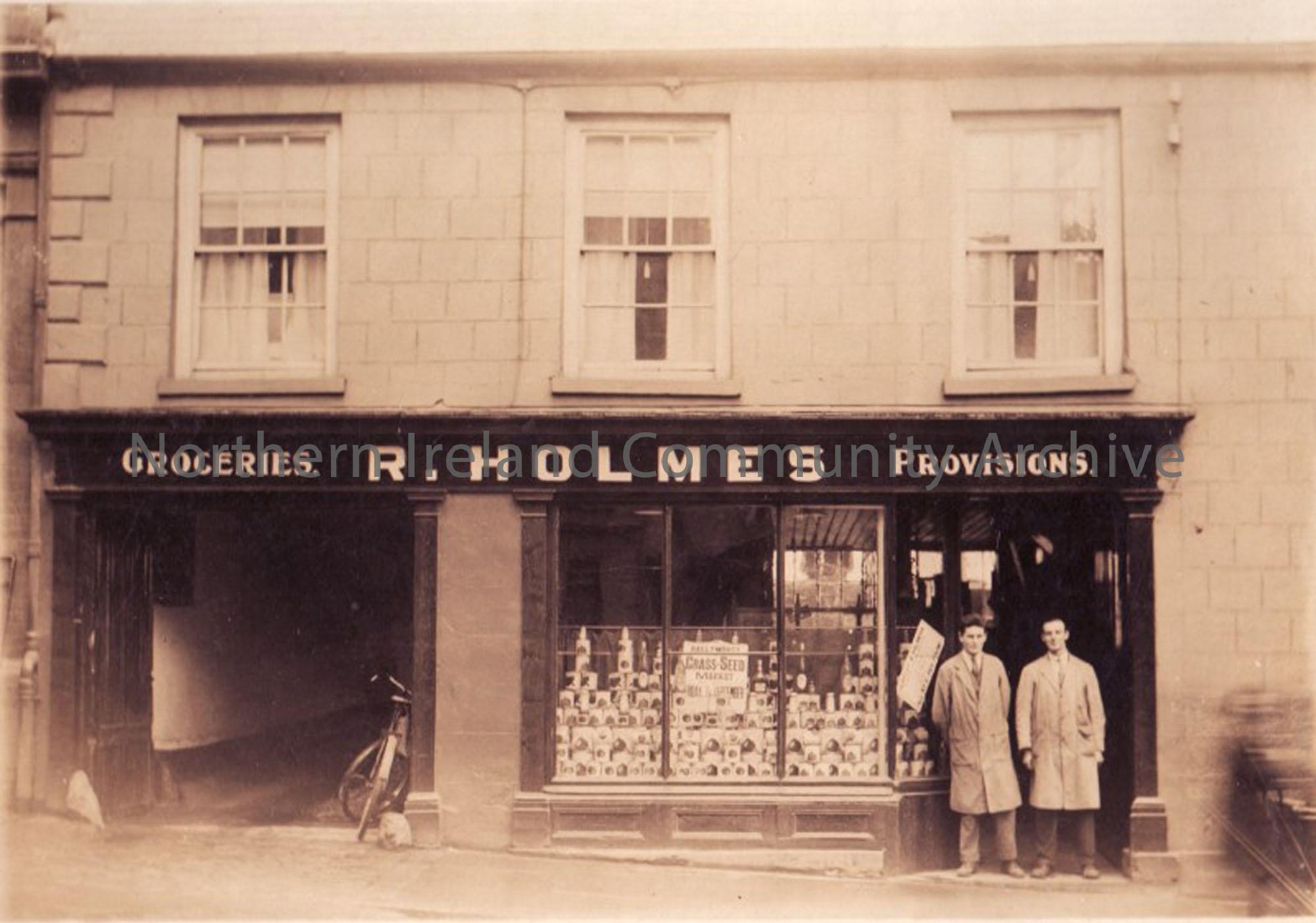 Donor’s father outside R. Holmes Grocery shop with another colleague c. 1920s
