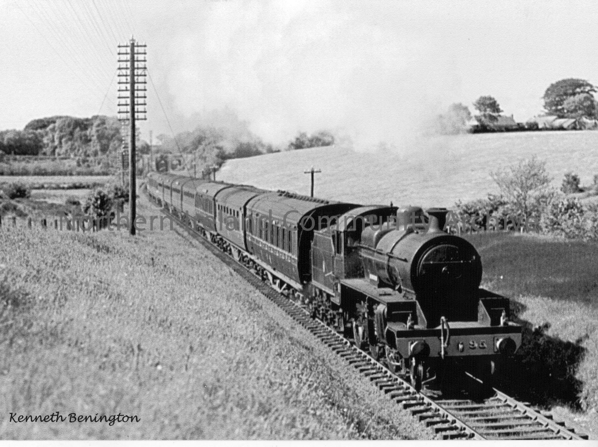 W class 2-6-0 No.95 ‘The Braid’ nears the top of the Ballymoney bank with an express to Belfast. The Dry Arch under the ‘Ballymena line’ is in the bac…