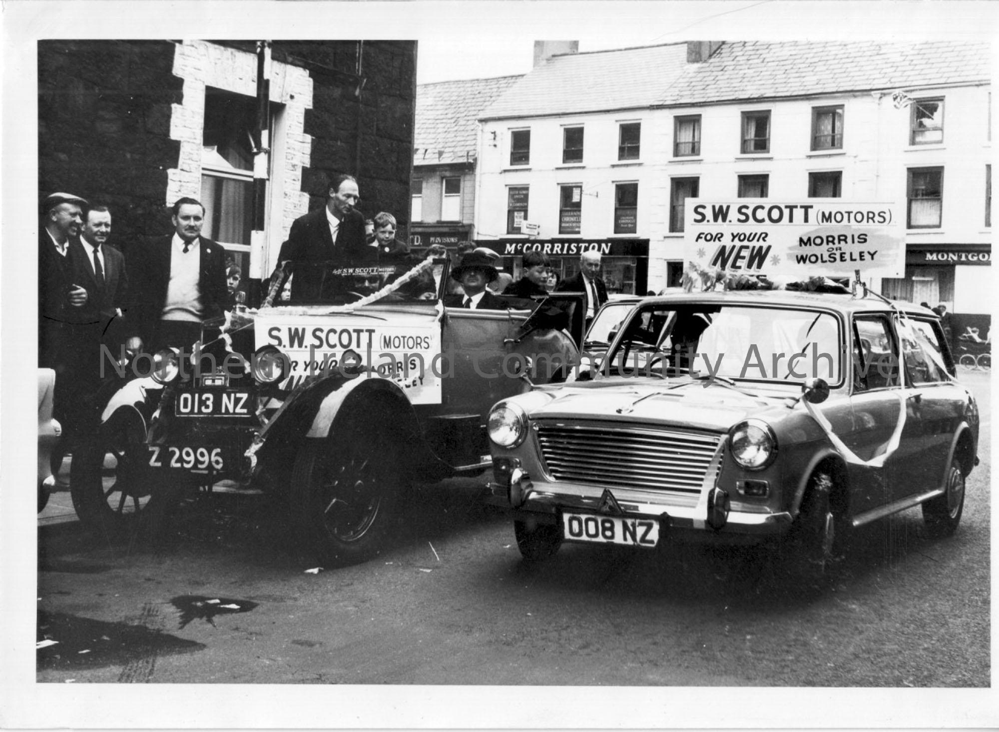 Photographic print of 2 S.W.Scott (Motors) cars with streamers and banners promoting their buisness for new Morris or Wolseley cars.