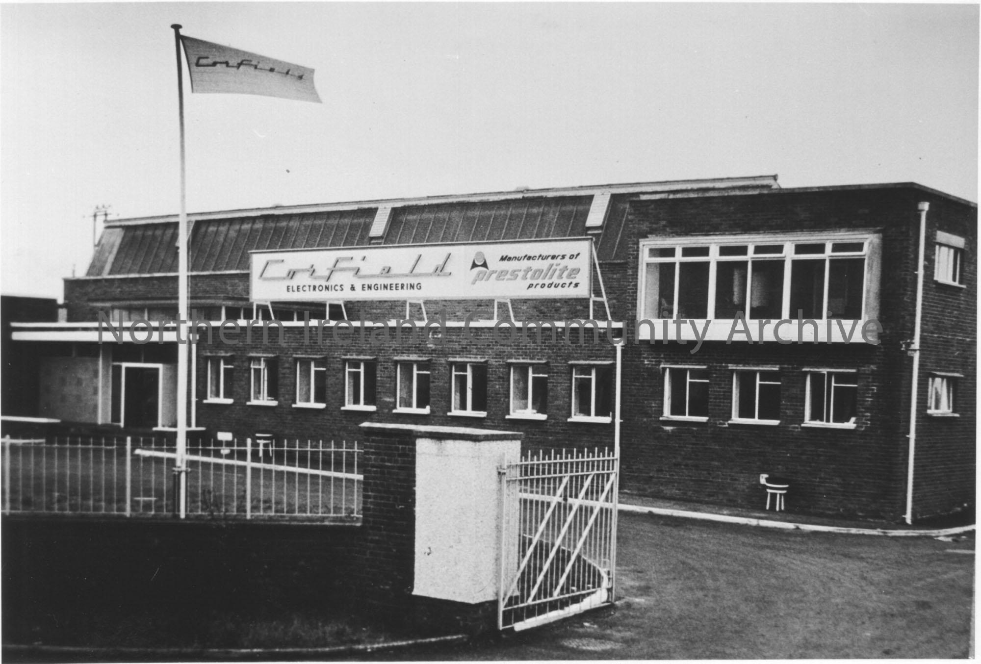 Photograph of Front view of Corfield Factory at Ballyema Road. Sign reads Manufacturers of Prestolite products, indicating the company was no longer i…