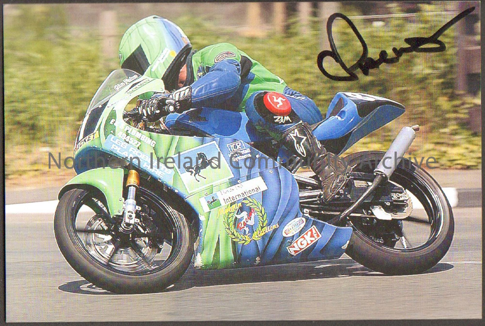 Signed photograph of Chris Palmer riding a green and blue motorbike wearing blue and green leathers in front of a hedge.