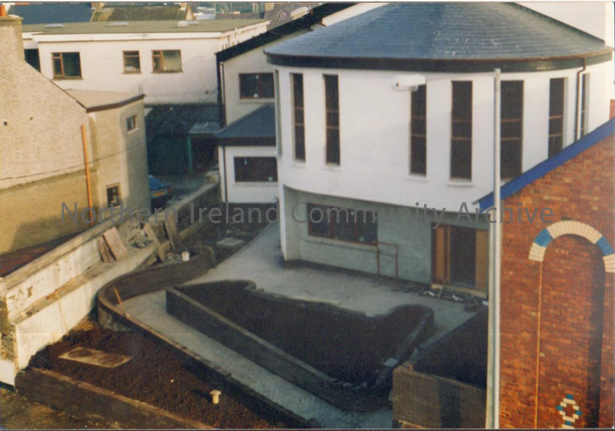 Colour photograph of the building of Riada House Extension. Aerial shot of a white rounded building with grey bottom.