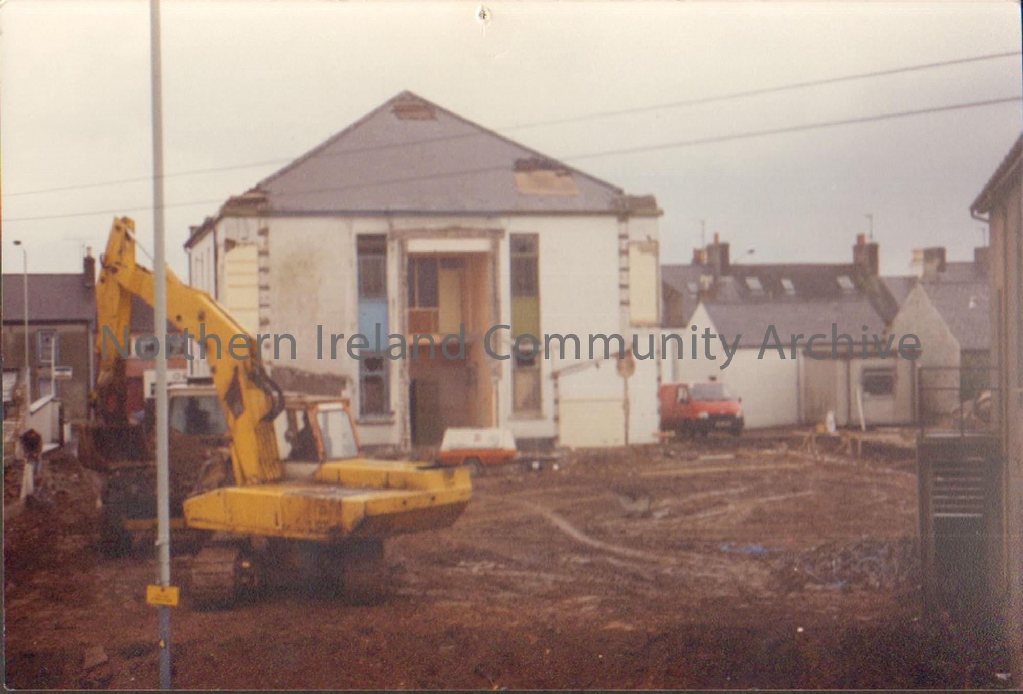 Colour photograph of the building of Riada House Extension. Image of a building site with a white building with a red van parked next to it in the bac…