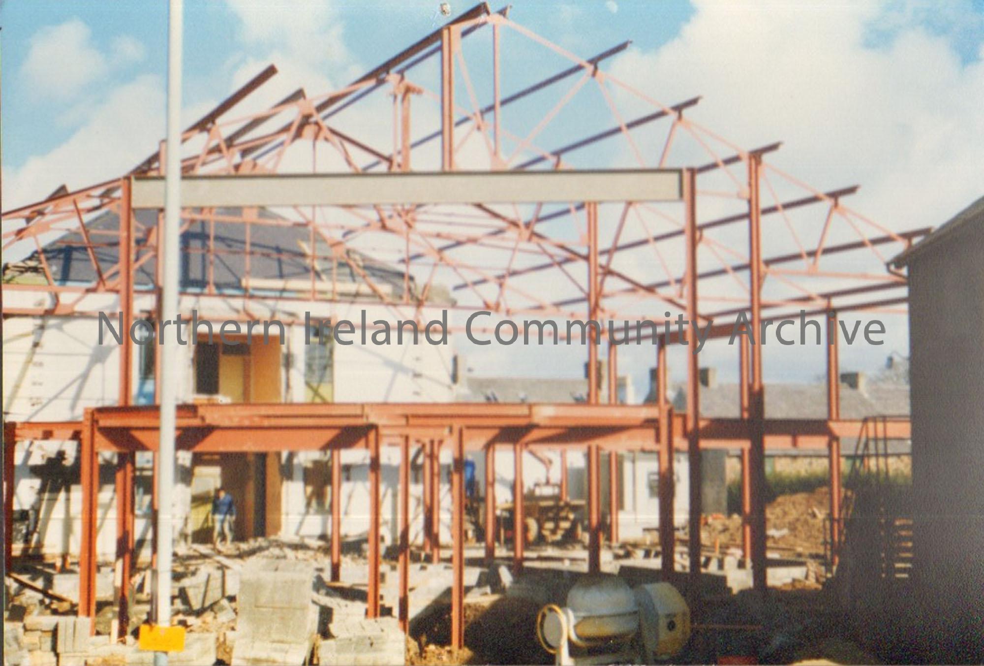 Colour photograph of the building of Riada House Extension. Image of red metal frame of a building on a sunny day.