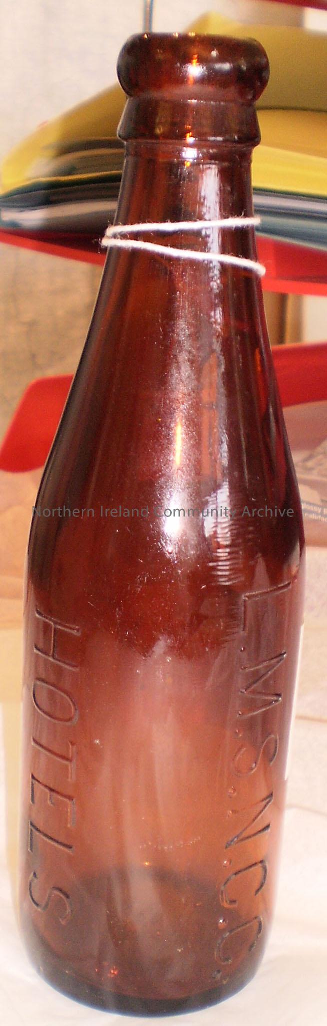 Brown glass bottle. Imprinted on the side is ‘L.M.S N.C.C Hotels’. This refers to London Midland and Scottish Railway, Northern Counties Committee and…