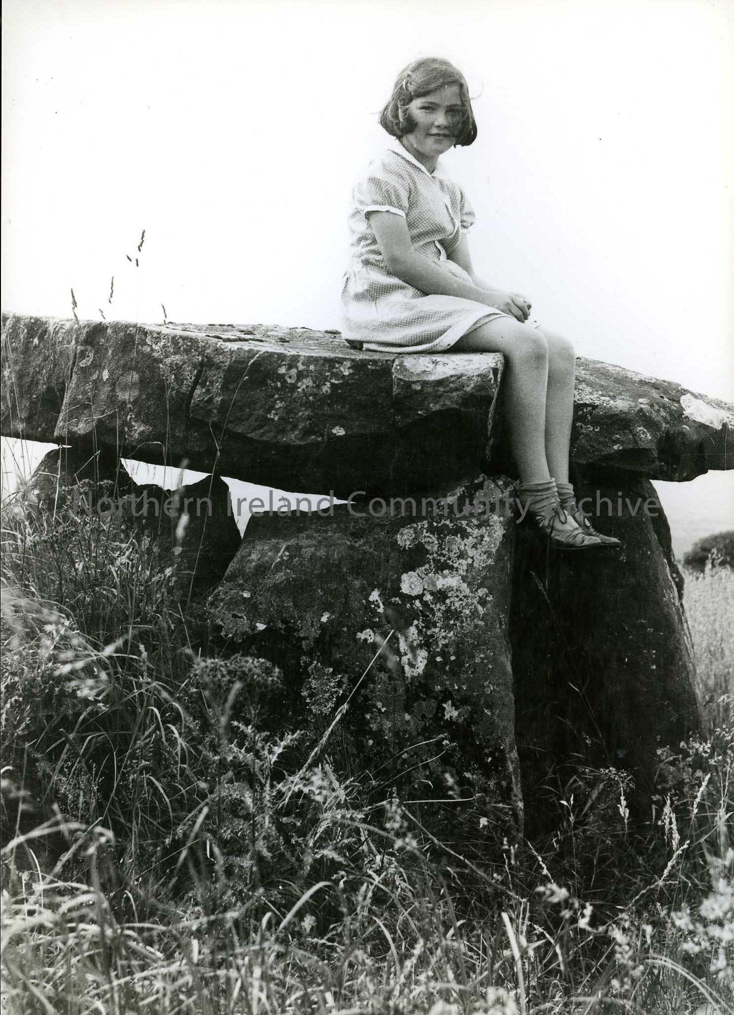 Printed black and white photograph – Olive Craig (nee Henry, Sam Henry’s daughter) sitting on a Cromlech.