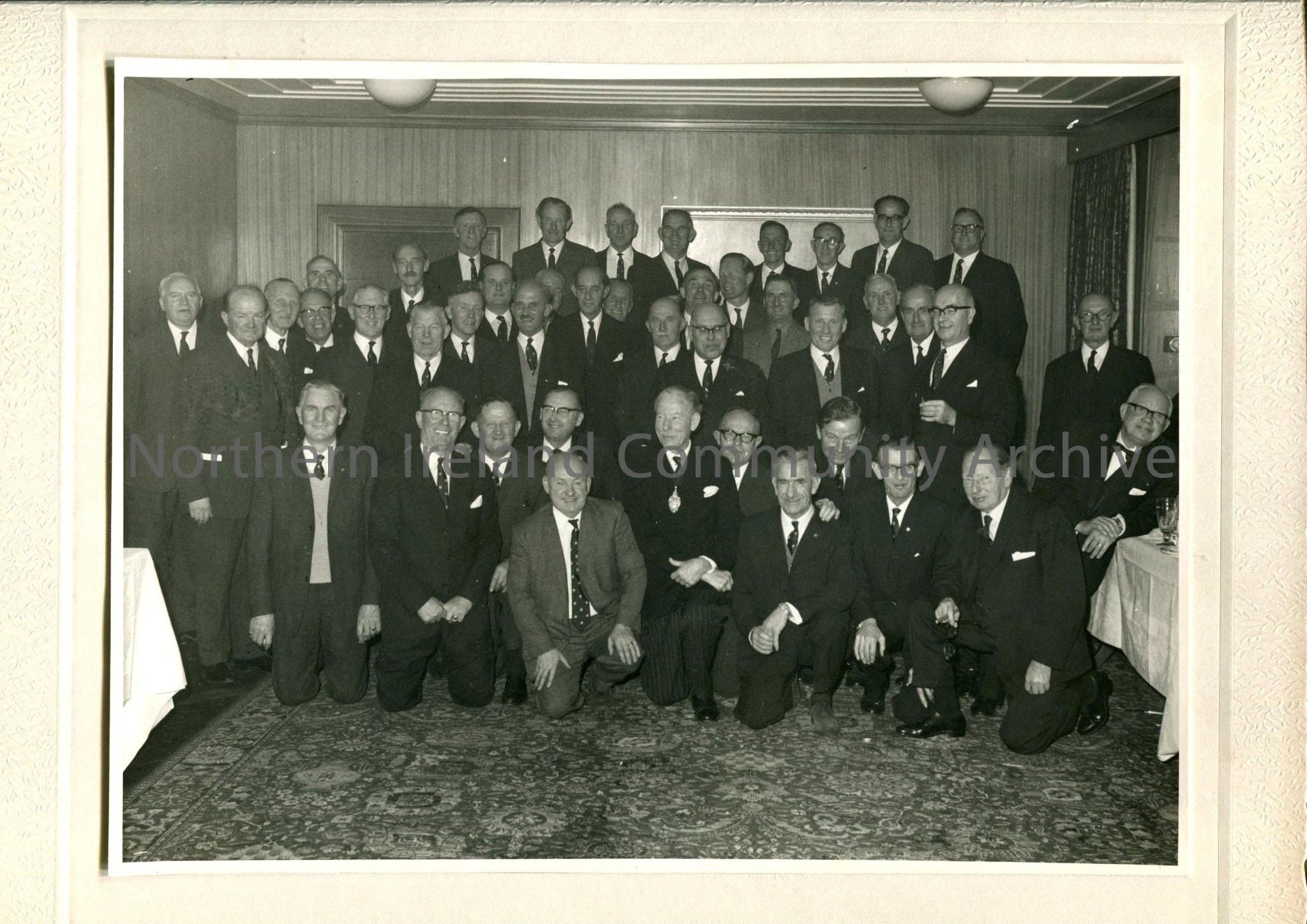 Black and white photograph of men in suits (Old Comrades Association – 6 Light AA Battery) contained inside a cream folder. Twenty nine of the men hav…