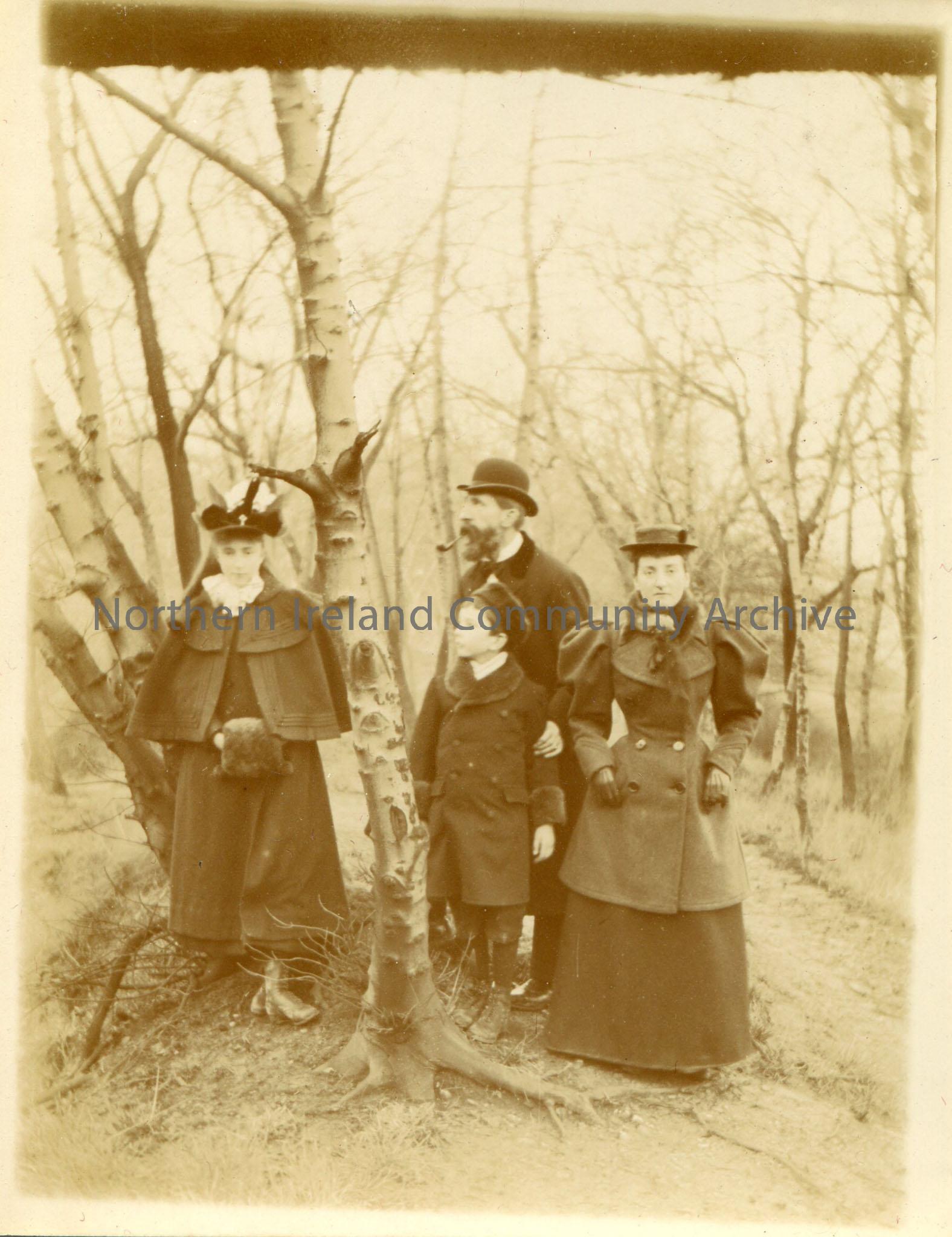Black and white photograph of a man and woman with a girl and boy in a woodland.