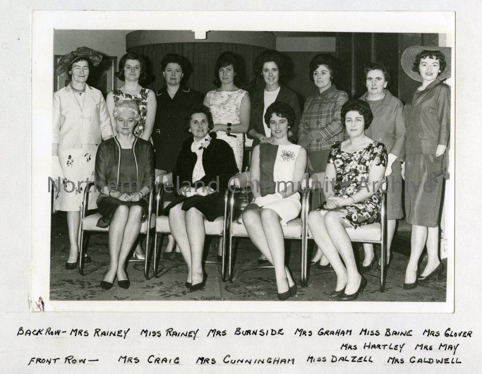 Fashion Show, Local Mannequins, 1964; Back Row: Mrs Rainey, Mrs Burnside, Mrs Graham, Miss Baine, Mrs Glover, Mrs Hartley, Mrs May.  Front Row: Mrs Craig, Mrs Cunningham, Miss Dalzell and Mrs Caldwell (5806)