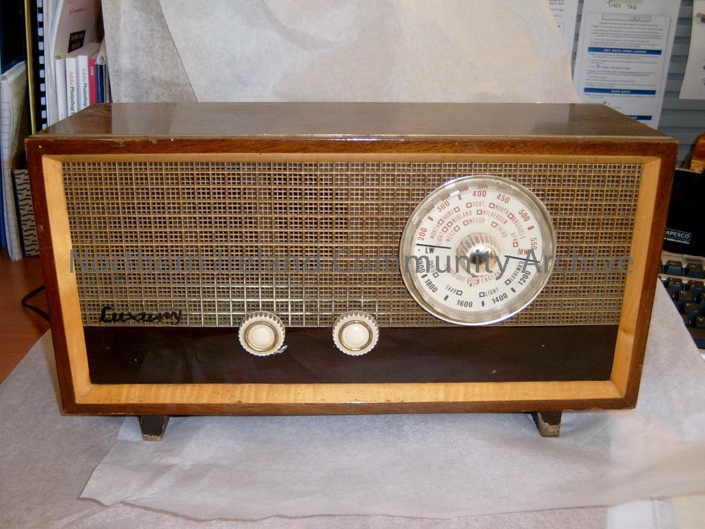 PYE wooden radio (from possibly 1950’s or 1960’s). One large dial on the right records different long wave and medium wave frequencies and different names of places including North, Home, Scot, North, Brussels, Light, Midland, Hilversum, AFN, West, Third. (6050)