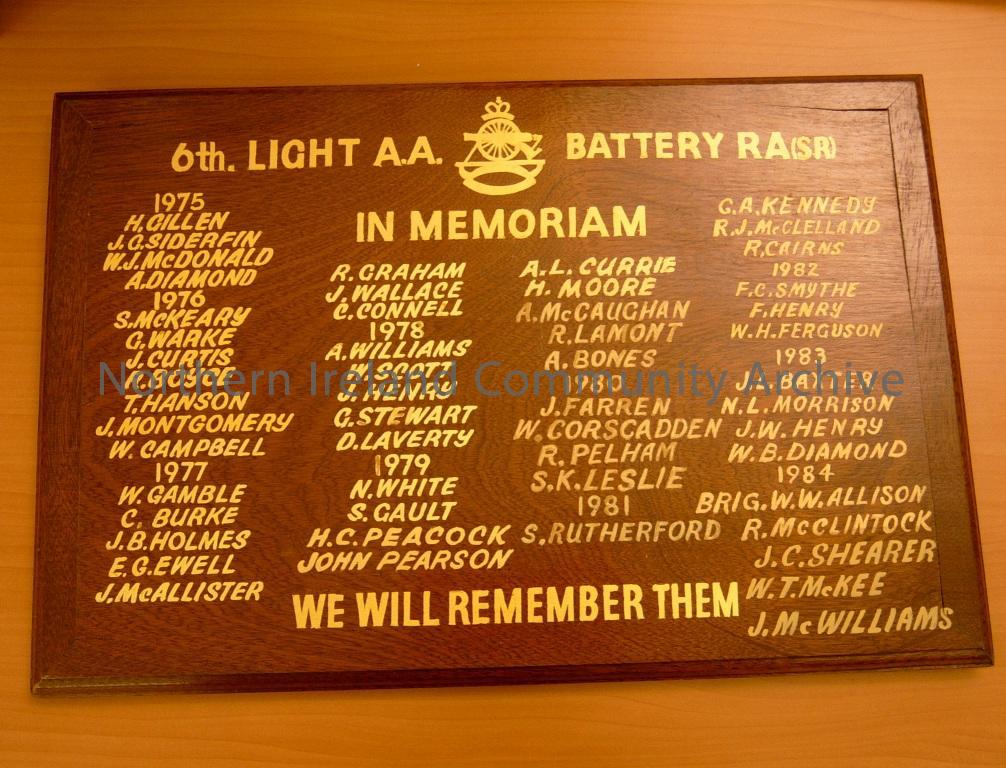 in memoriam wooden board with stand attached on back. For the 6th Light A A Coleraine battery RA (SR). We Will Remember Them, it records the names of the veterans that served and the years they died from 1975-1984 in gilt (1889)
