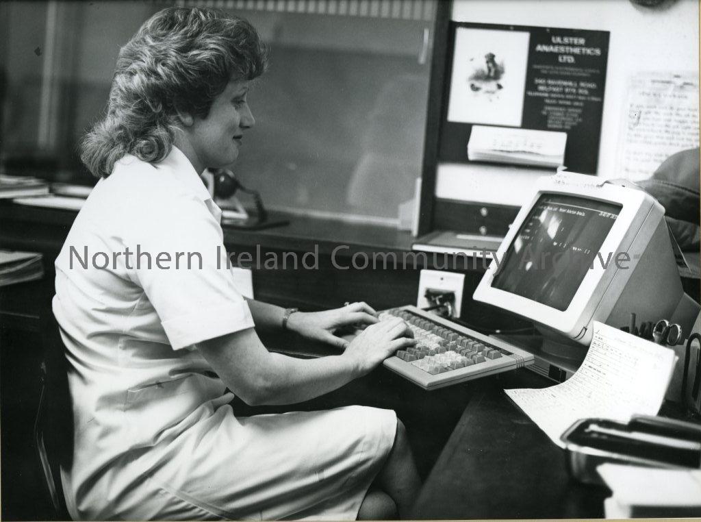 black and white photograph of a lady inserting data to a computer (4207)