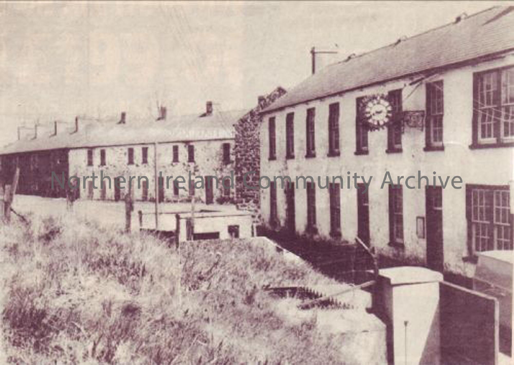Mill workers houses in Balnamore Mill. The building on the right had 2 houses and the canteen on the ground floor, with a large hall and a school house on the first floor, where the clock is. You can also see the gates into the mill in the foreground. (5026)