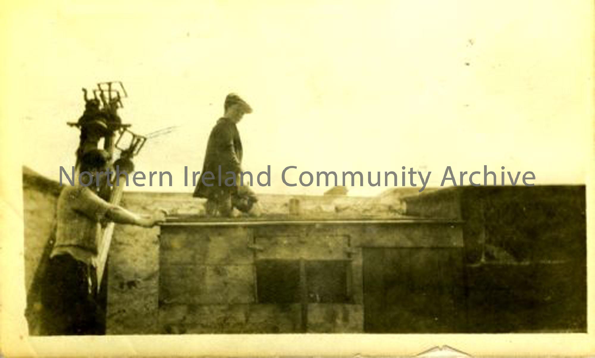 Foncie McErlain mending the roof at McErlain’s. The McErlains were rabbit and poultry dealers whose house and business stood where the Castle Community Association building is now. (5880)