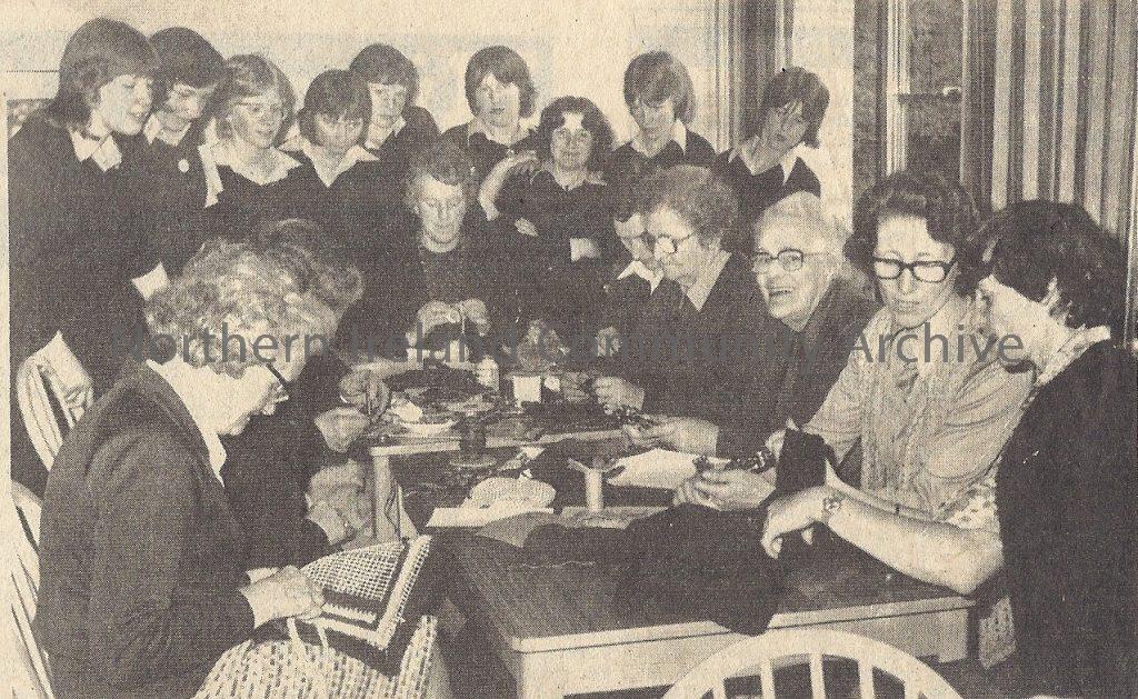 Women’s Institute members during a two day exhibition of handicrafts at the Roe Valley Country Park. Looking on are some pupils of St. Patrick’s Secondary School, Dungiven.