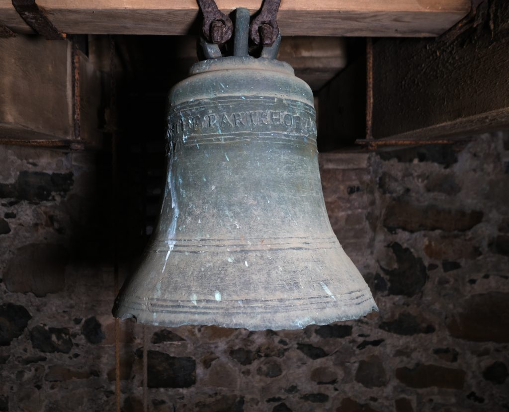 Photograph of the small bell, dated 1695, in the tower of St Guaire's Church.