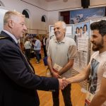 Project participants Mohamed and Basil with the Mayor of the Causeway Coast and Glens, Councillor Steven Callaghan at the exhibition in Coleraine Town Hall.
