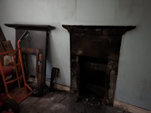 Photo of an empty room showing period fireplace.